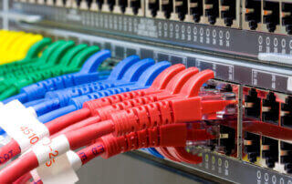 Red, blue, green and yellow patch cables connected to a network switch