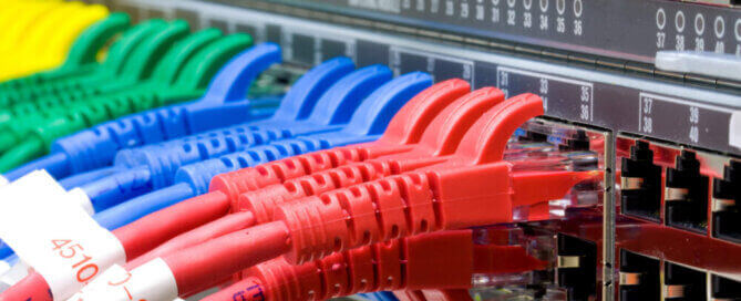 Red, blue, green and yellow patch cables connected to a network switch
